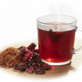 Rooibos and Hibiscus Herbal Blend Tea in a glass mug with deep burgundy color, rooibos leaves and hibiscus flowers
