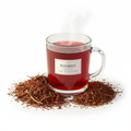 Organic Rooibos Tea in a glass mug with rich red color and dried rooibos leaves