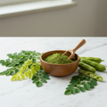 Organic Moringa Powder in bowl with fresh moringa leaves